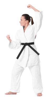 Kimonolu genç bir kadın beyaz arka planda karate yapıyor.