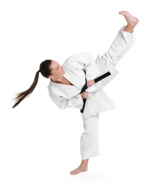 Kimonolu genç bir kadın beyaz arka planda karate yapıyor.