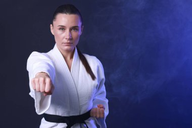 Koyu mavi arka planda kimonolu karate dövüşçüsü, metin için boşluk