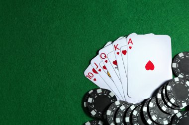 Yeşil masada kağıt ve poker fişleri, düz yatış. Metin için boşluk