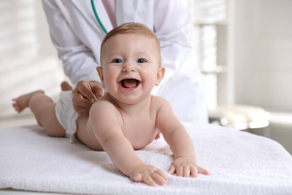 Pediatrician examining little child with stethoscope in clinic, closeup. Checking baby's health