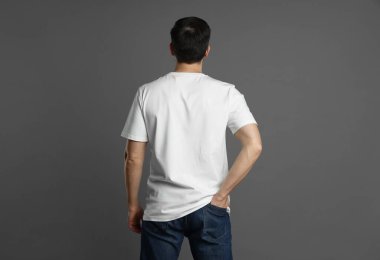Gri arka planda beyaz tişörtlü adam, arka plan. Tasarım için model