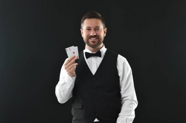 Siyah arkaplanda oyun kartları olan profesyonel krupiye