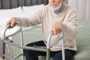 Evdeki yatağında yürüyen çerçeveli son sınıf öğrencisi, yakın plan.