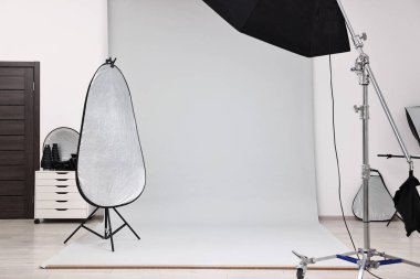 Professional lighting equipment setup in modern photo studio clipart