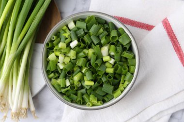 Kasede doğranmış yeşil soğan ve sapları beyaz mermer masa, üst manzara