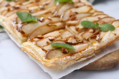 Beyaz masada armut ve nane aromalı lezzetli börek, yakın plan.
