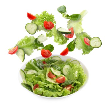 Lezzetli salata. Taze malzemeler ve beyaz arka planda havadaki yemekler.