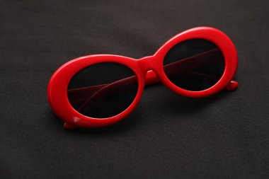 Siyah arka planda şık güneş gözlükleri, yakın plan. Zarif aksesuar.