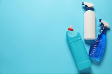 Açık mavi arka planda temizlik ürünleri, üst manzara. Metin için boşluk