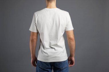 Gri arka planda, şık tişörtlü bir adam. Tasarım için model