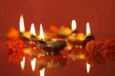 Diwali kutlaması. Diya lambaları ve arkaplanda güzel çiçekler, yakın plan