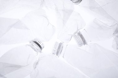 Kırışmış plastik şişeler beyaz arka planda, yakın plan.