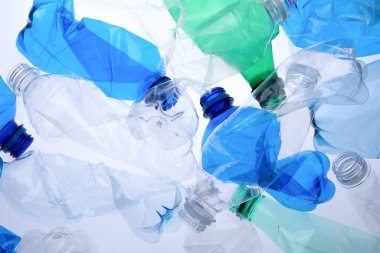 Kırışmış plastik şişeler beyaz arka planda, yakın plan.