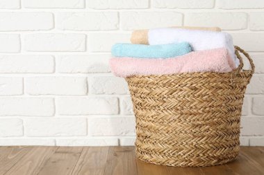 Tahta masada çamaşır dolu bir sepet, metin için yer var.