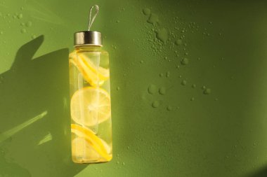 Islak yeşil arka planda limonlu su, üst manzara. Metin için boşluk