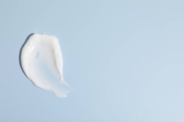 Açık mavi arka planda krem örneği, üst manzara. Metin için boşluk