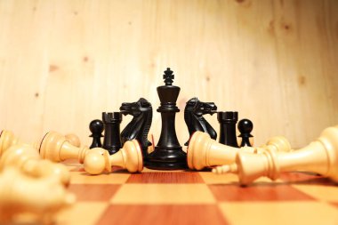 Satranç tahtasındaki diğer düşmüş beyaz taşların yanında siyah satranç kralı. Rekabet konsepti