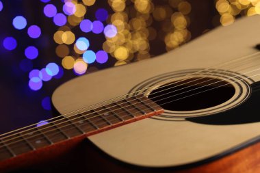 Gitar bulanık ışıklara karşı, yakın plan. Bokeh etkisi