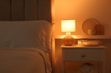 Şık bir oturma odası. Yatağı, yatağı ve lambası var.