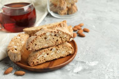 Geleneksel İtalyan bademli bisküvileri (Cantucci) ve gri desenli masa üzerinde çay, yakın plan. Metin için boşluk