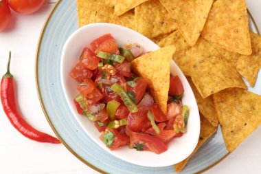 Lezzetli salsa (Pico de gallo) beyaz ahşap masada nachos ve chili biber ile servis edilir.
