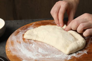 Gri masada pizza yapan kadın, yakın plan.