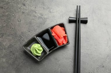 Sıcak wasabi ezmesi, soya sosu, zencefil ve çubuklar gri desenli masa, üst manzara
