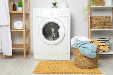 Banyoda yerde çamaşır dolu bir sepet.