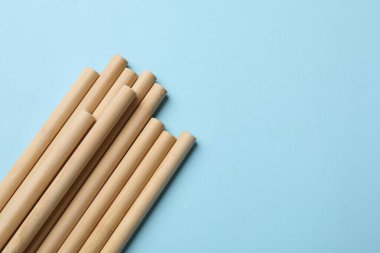 Açık mavi arka planda bambu pipetleri, üst manzara. Metin için boşluk