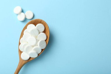 Antibiyotik haplar ve açık mavi arka planda kaşık. Metin için boşluk