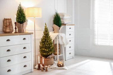 Noel ışıkları ve diğer dekorları olan küçük ladin ağaçları.