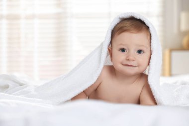 Havlunun altındaki şirin bebek evde yatakta yatıyor.