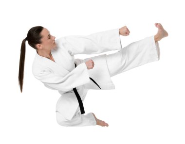Kimonolu genç bir kadın beyaz arka planda karate yapıyor.