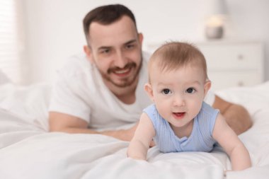 Babası evde tatlı bebeğiyle yatakta, seçici bir şekilde odaklanmış.