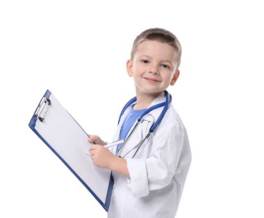 Stetoskop ve not panosuyla beyaz arka planda doktor gibi davranan küçük bir çocuk. Geleceğin mesleğini hayal etmek