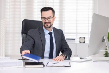Ofiste çalışan gülümseyen bir bankacı.
