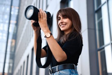 Binanın yakınında dijital kamerası olan profesyonel bir fotoğrafçı.