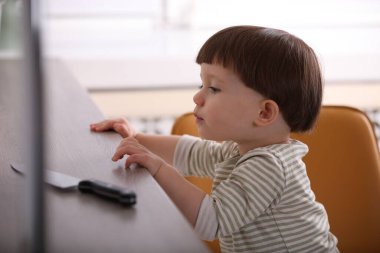 Küçük çocuk mutfak tezgahında bıçağa uzanıyor. Tehlikeli bir durum.