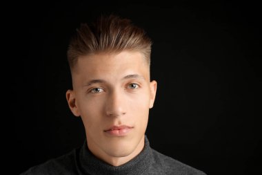 Siyah arka planda şık saç kesimi olan kendine güvenen genç bir adam. Metin için boşluk