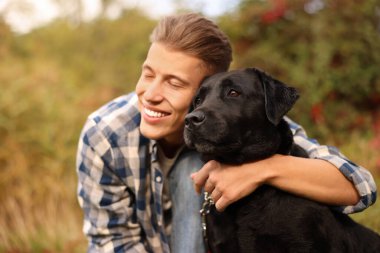 Gülümseyen adam ve sevimli köpek sonbahar günü açık havada