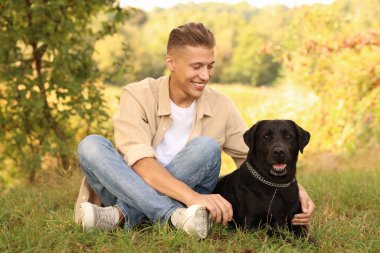 Gülümseyen adam ve sevimli köpek sonbahar günü açık havada