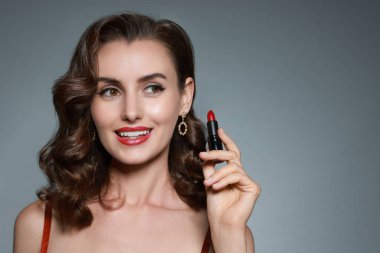 Gri arka planda kırmızı rujlu gülümseyen kadın. Metin için boşluk