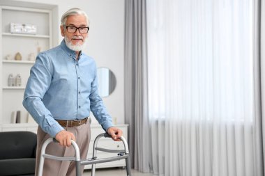 Kıdemli adam evde yürüyüş çerçevesi kullanıyor. Metin için boşluk