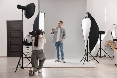 Profesyonel fotoğraf stüdyosunda modelle çalışan bir fotoğrafçı.