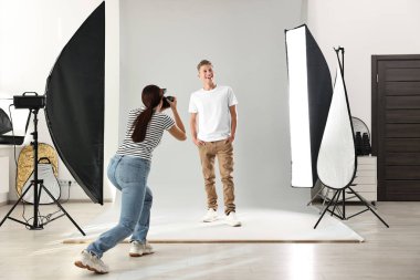 Profesyonel fotoğraf stüdyosunda modelle çalışan bir fotoğrafçı.