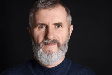 Siyah arka planda kıdemli bir adamın portresi