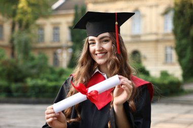 Mezuniyet töreninden sonra diplomalı mutlu bir öğrenci.