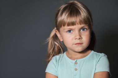 Yetimhane konsepti. Gri arka planda üzgün küçük kız, mesaj için boşluk