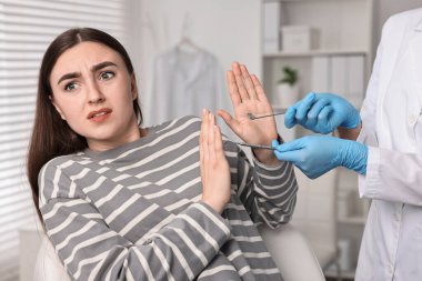 Dental phobia. Dentist working with scared woman in clinic, closeup clipart